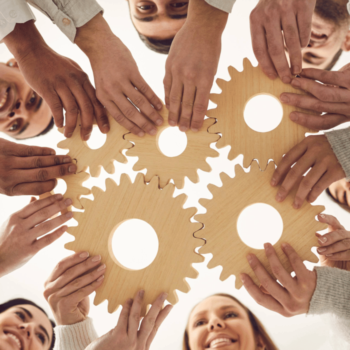 People holding wooden gears